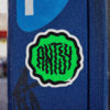 square-green-antsy-round-sticker-on-a-blue-parking-meter